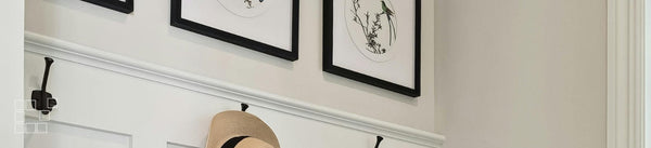 Entryway and hallway wall art above white panelling and coat hooks