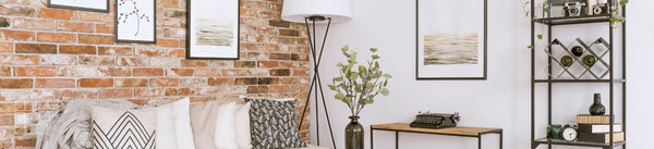 Living room wall art above a sofa beside exposed brick and shelving