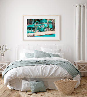 Chrome door handle beneath the turquoise steering wheel and curved gauges