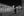 Two softly blurred figures on stone paving beneath the lit architecture of St Mark’s Square