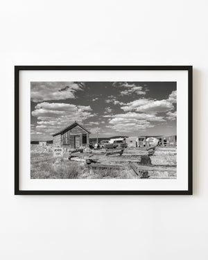 Abandoned schoolhouse in Currie, Nevada, with a School Zone sign, photographed in black and white.