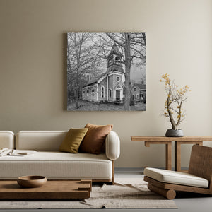 Bare branches frame an abandoned rural church with a round window above its doorway.