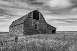 Verweerde houten schuur op de landelijke Saskatchewan-landbouwgrond zwart-wit foto