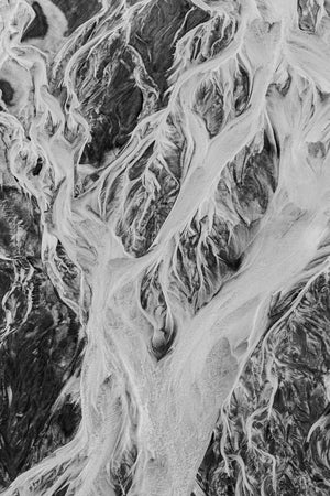Vertical monochrome aerial photograph of branching coastal channels in Alaska.