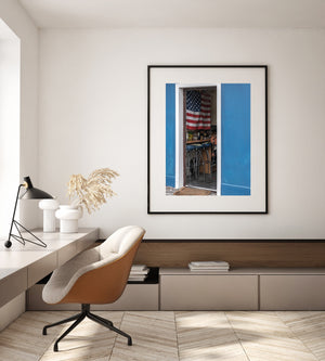 White doorway trim separates a dark flag-filled interior from the bold blue exterior.