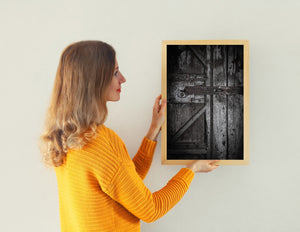 Monochrome detail of a keyhole, rounded fastenings and cracked wooden panels.