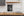 Long iron latch crossing vertical wood grain and angled door trim.
