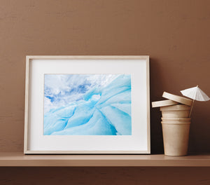 Broad ice slopes crossing narrower ridges beneath a blue and white Antarctic sky.