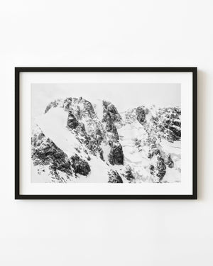 Black and white Antarctic rock faces divided by deep snow.