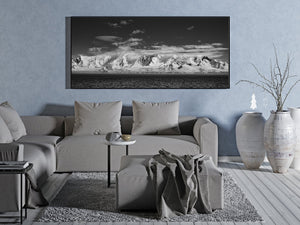 Wide Antarctic coastal photograph contrasting bright snow and dark water.