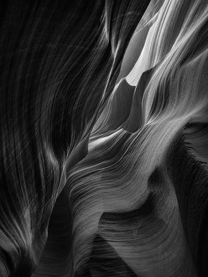 Fine sandstone bands sweeping through shadow inside Antelope Canyon.