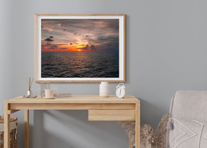 Colour seascape of dark Atlantic ripples and bright sunset light at the horizon.