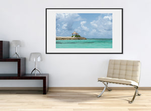 Pale aqua ripples lead toward a small shelter on the rocky Bahamas shoreline.