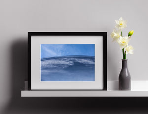 White cloud streaks ripple across a rounded blue reflective surface.