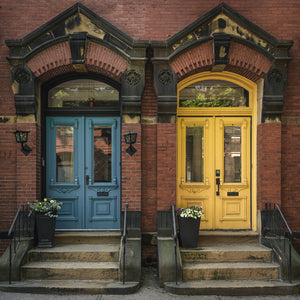 Paired historic entrances with blue and yellow doors in Saint John.