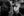 A seated Boston subway employee looks sideways past a standing passenger