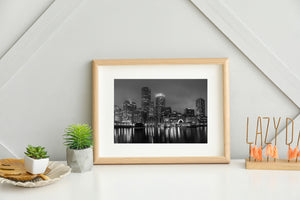 Boston skyline and a waterfront boat beneath layered night fog