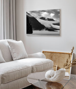 Layered coastal mountains and soft fog create a monochrome Canadian landscape.