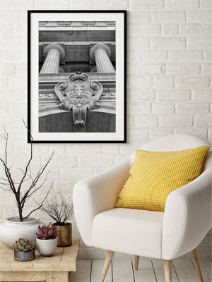 Fotografía arquitectónica de columnas en blanco y negro y adorno de fachada tallado.