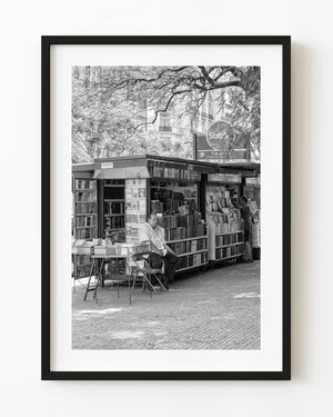 Black and white photograph of a street bookseller in Buenos Aires.