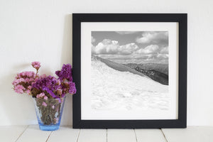 Black and white mountain scene with rough snow texture and receding ridgelines.