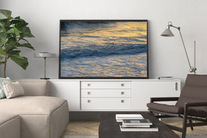 California ocean photograph with bands of blue waves and golden reflected light.