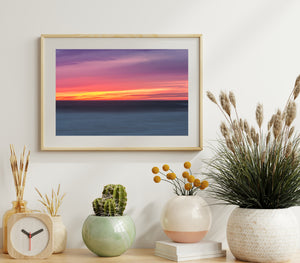 Colour seascape of a California evening with a calm blue ocean and vivid sunset sky.