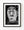 Black and white photograph of an expressive carved wooden face holding a cigar.