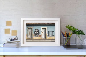 Murale de rue Che Guevara à côté d'une porte sous le toit bas en tuiles d'un bâtiment cubain.