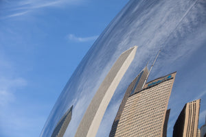 Cloud Gate bends reflections of tall Chicago facades into sweeping diagonal shapes.
