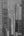 Tall Chicago buildings frame a narrow strip of sky and a distant tower in monochrome.