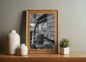 A circular window interrupts rows of wooden shingles in Chofu Garden’s traditional architecture.
