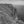 An Irish cliff-top tower overlooks steep rock faces and open Atlantic water in monochrome.