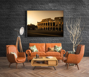 Warm evening light outlines the Colosseum’s curved facade and tiers of arches.