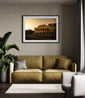 Horizontal architectural photograph of the Colosseum with amber light and dark stone arches.