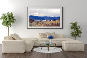 Wide California desert photograph with colourful ridges, distant mountains and a pale sky.