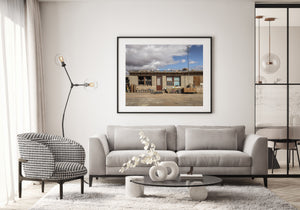 A converted gas station displays rustic architectural details beneath a broad clouded sky.
