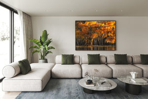 Warm orange leaves fill a waterside cypress scene above a narrow reflective band.
