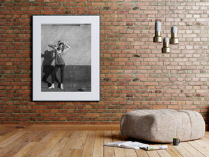 Girl making a defiant gesture against a pale stone wall in Buenos Aires.