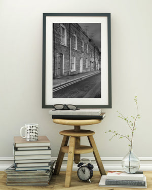 Brick facades and pale door surrounds beside an empty street in Derry.
