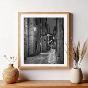 Calle de Dubrovnik en blanco y negro al atardecer con lámparas a lo largo de una calle estrecha