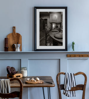 Pewter plates on a rustic table beside a Dutch kitchen hearth