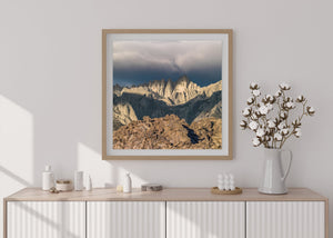 Pale mountain spires against a deep blue-grey cloud bank