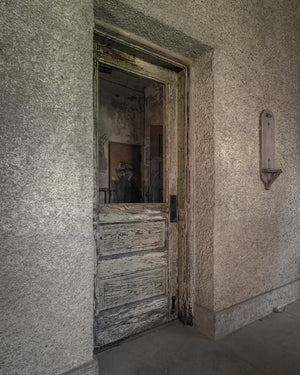 Muted colour photograph of an abandoned hospital doorway on Ellis Island.