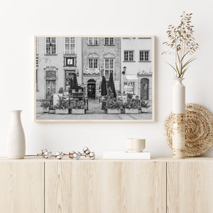 Black and white architectural photograph of neighbouring storefronts and a Polish café terrace