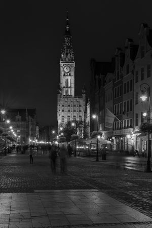 Streetlights lead toward Gdańsk Main Town Hall’s clock tower after dark