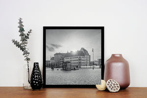 Ornate streetlamps rise beside a German square with scattered pedestrians