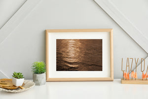 An abstract water photograph shows shimmering reflections and deep brown shadows