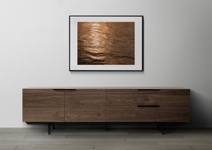 Golden highlights and bronze waves form a richly textured ocean reflection