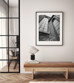 Verwittertes Mauerwerk und hohe Fenster füllen eine dramatische monochrome Basilikaansicht